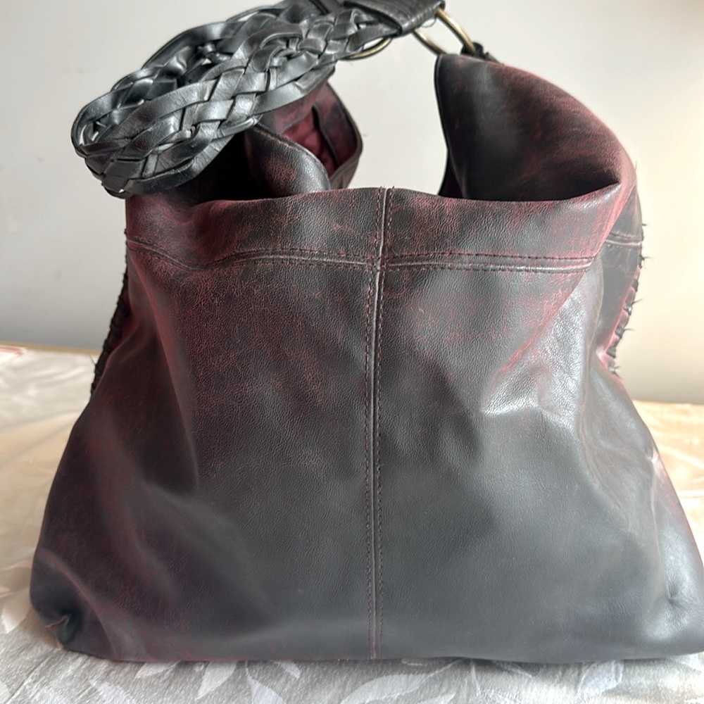 shoulder tote with patina maroon leather. Great sewn leather sides. Braid strap